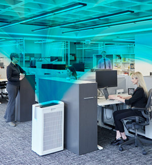 Office setting with Performance Series Air Purifier visually showing airflow in blue